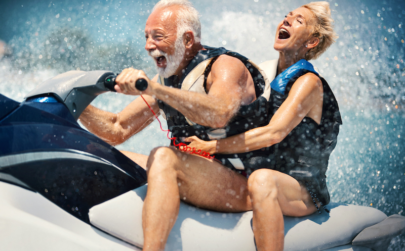 older caucasian couple having fun on a jet ski in the summer